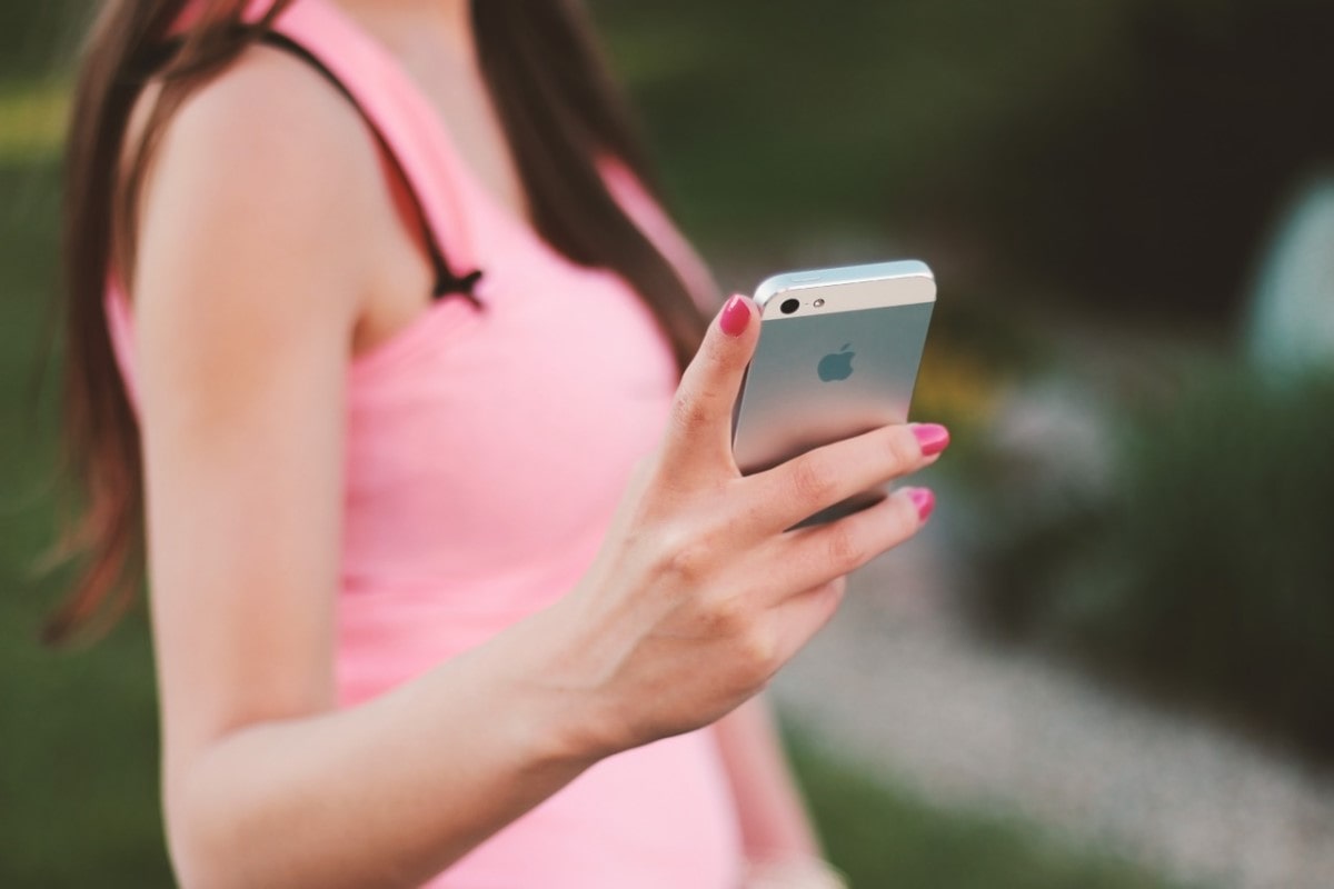 Mujer investigando en su celular la ronda de inversión de Rappi.