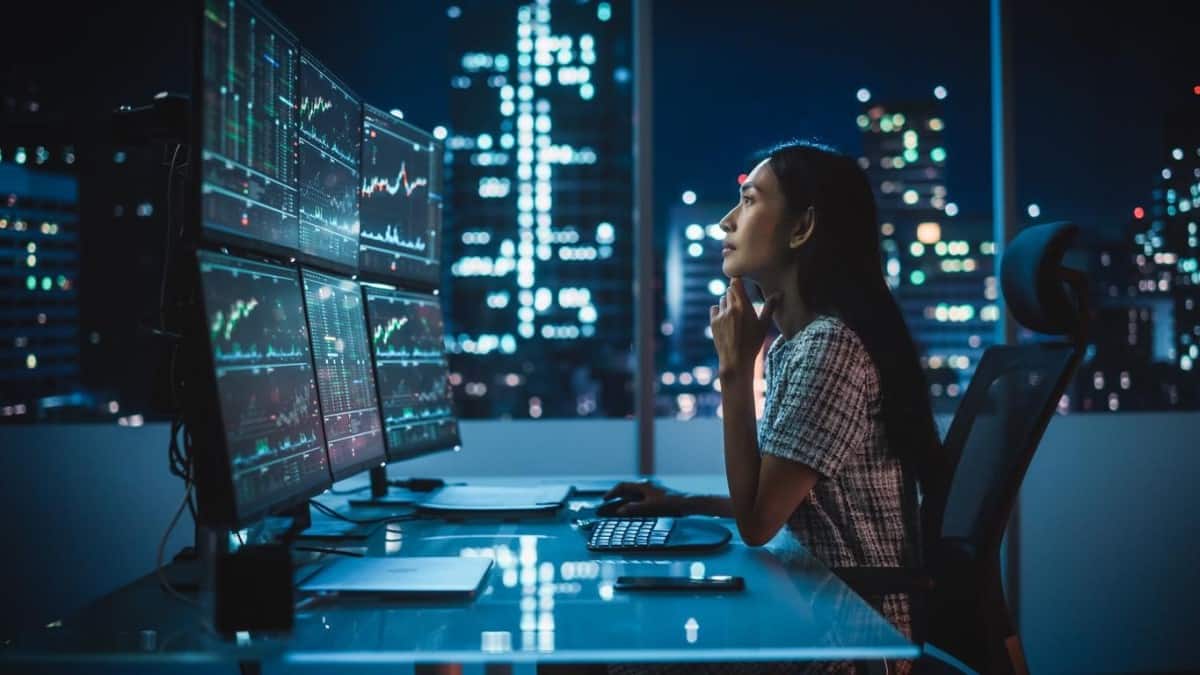 Trader analiza en computadoras gráficos para invertir. Descubre qué es la bolsa de valores.