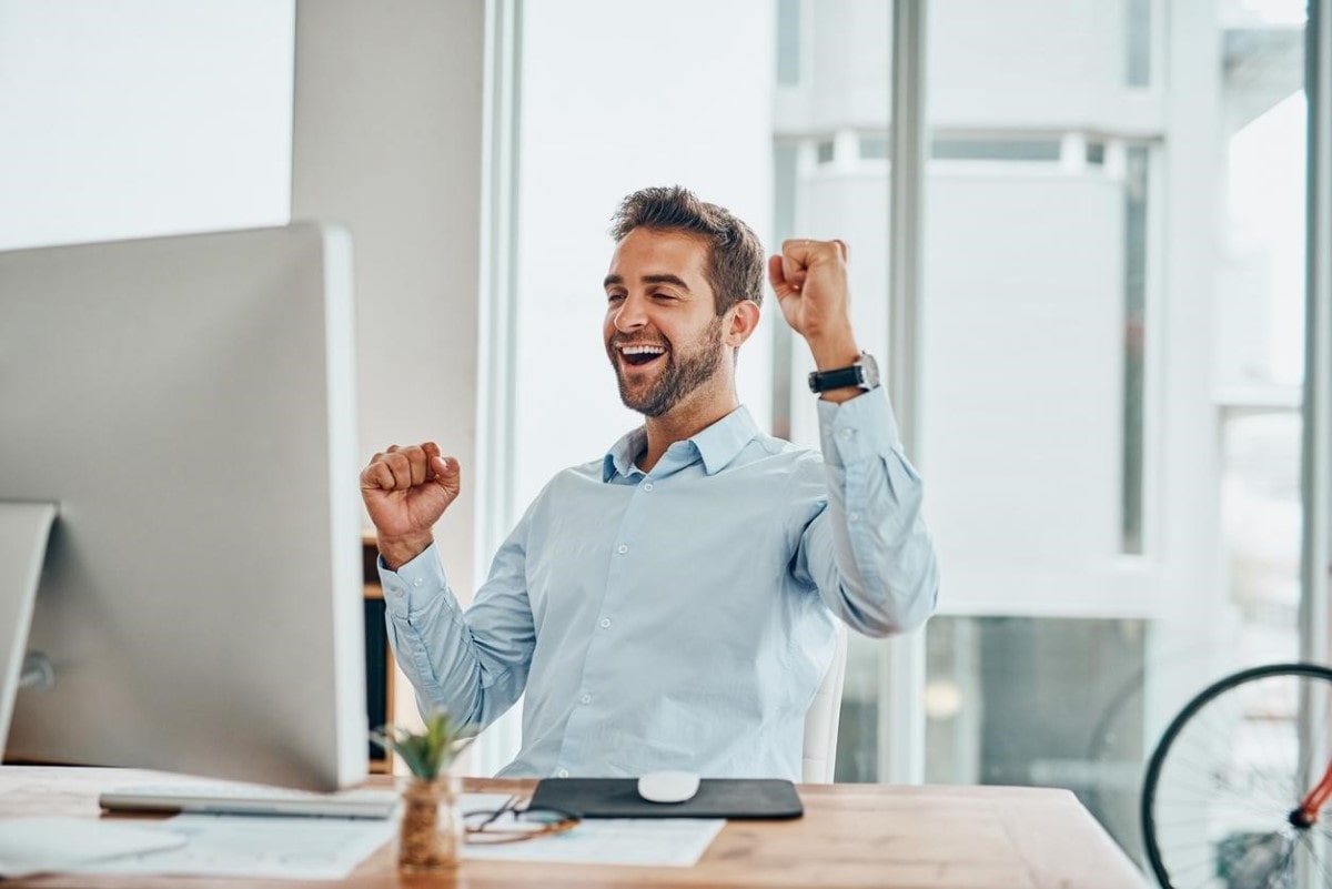 Hombre celebra tras descubrir cómo comprar acciones de una empresa por Internet.