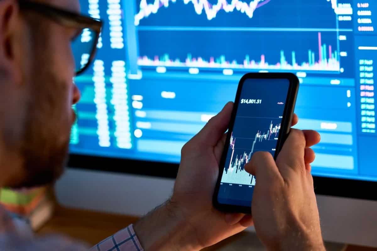 Inversor analiza los gráficos de criptomonedas desde el celular