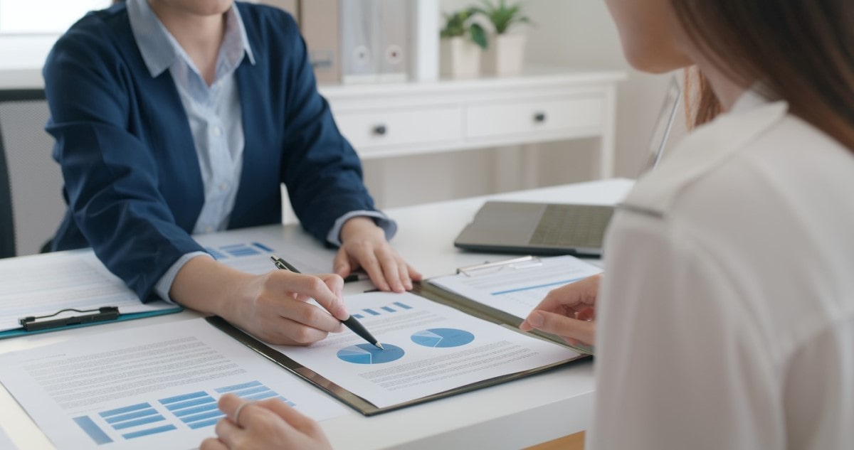 Empresarios revisan gráficos y analizan la posibilidad de invertir en un fondo de inversión indexado.