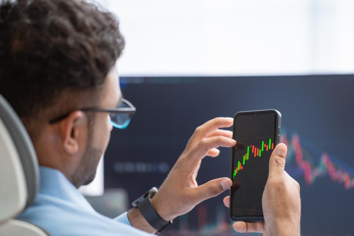 Un trader analiza tendencias en su celular sobre el índice IPP.