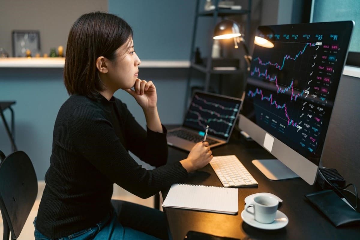 Mujer joven analiza desde su computadora estrategias de inversiones en Argentina