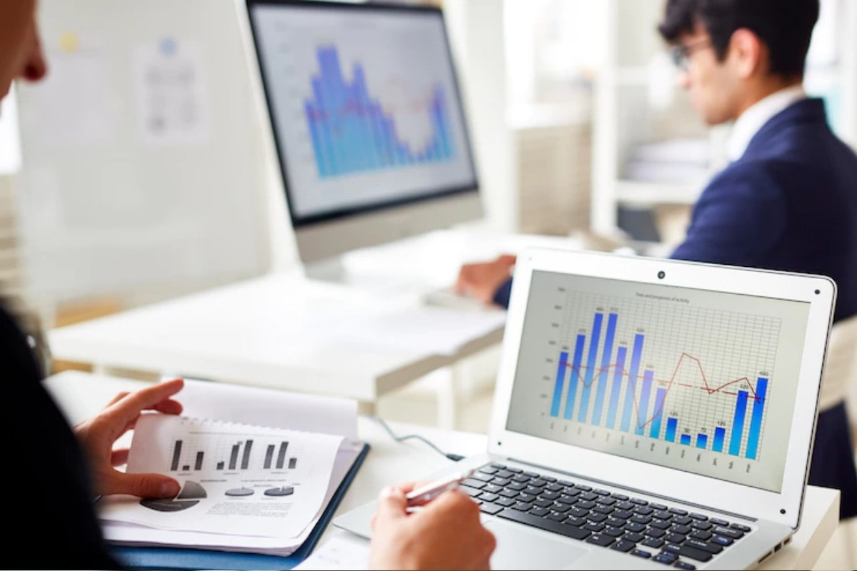 Empresarios analizando gráficos en sus computadoras