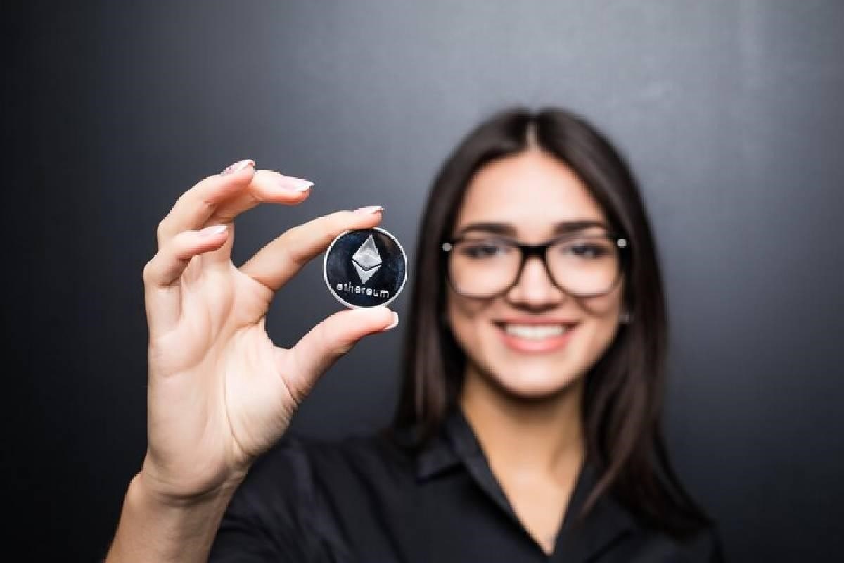Una mujer sosteniendo una criptomoneda Ethereum, una de las mejores para invertir.