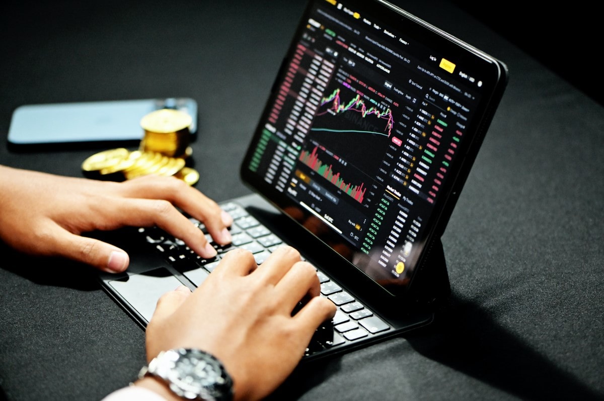 Persona viendo gráficos del mercado financiero en una computadora.