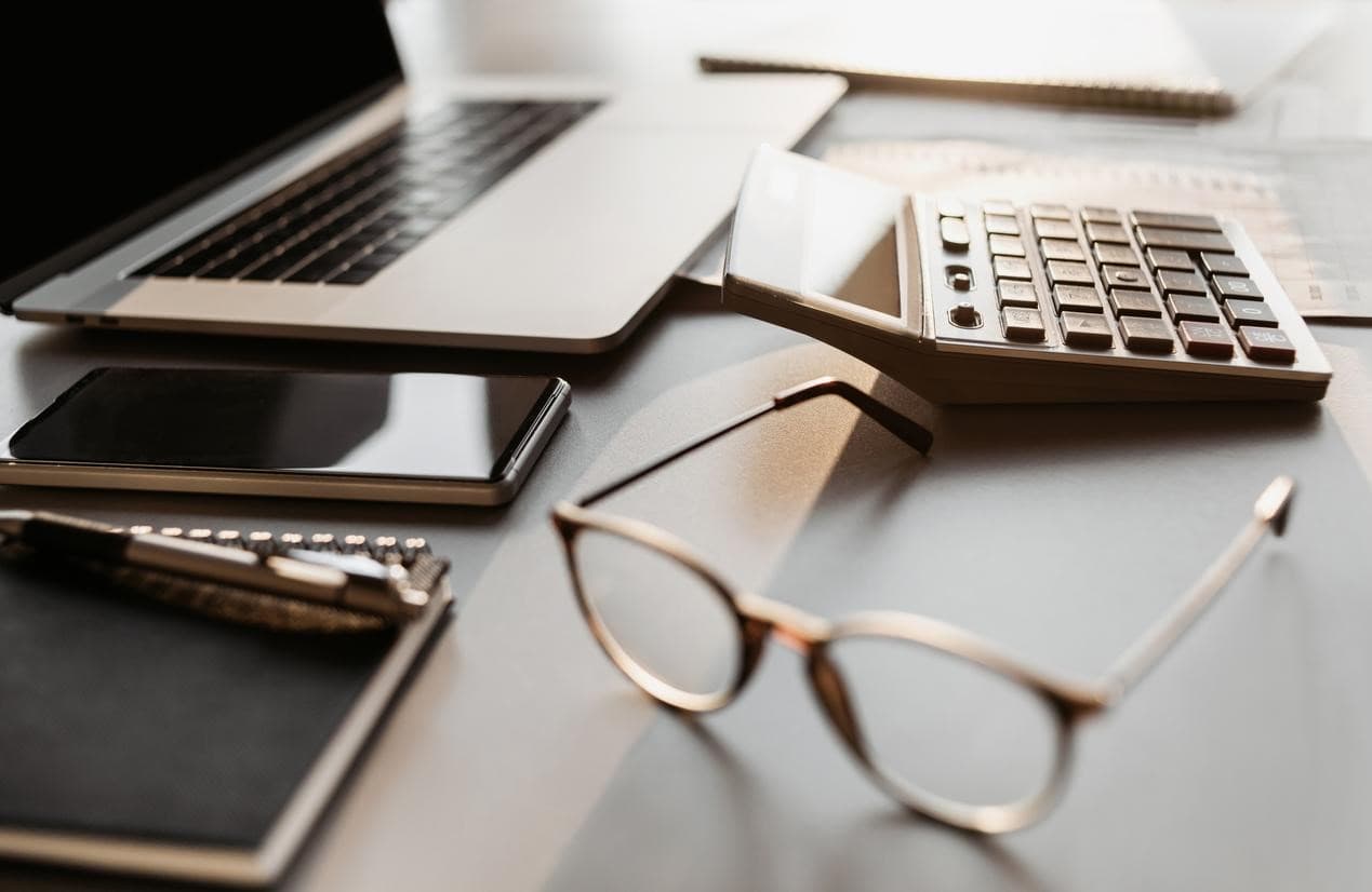 Laptop, calculadora, celular y otras herramientas útiles para la planificación financiera.