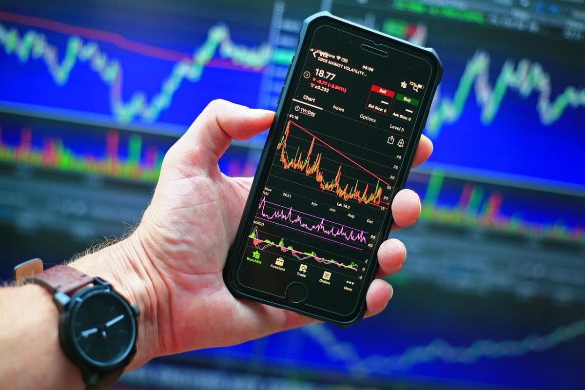 Persona viendo en su celular gráficos que muestran el comportamiento de sus inversiones.
