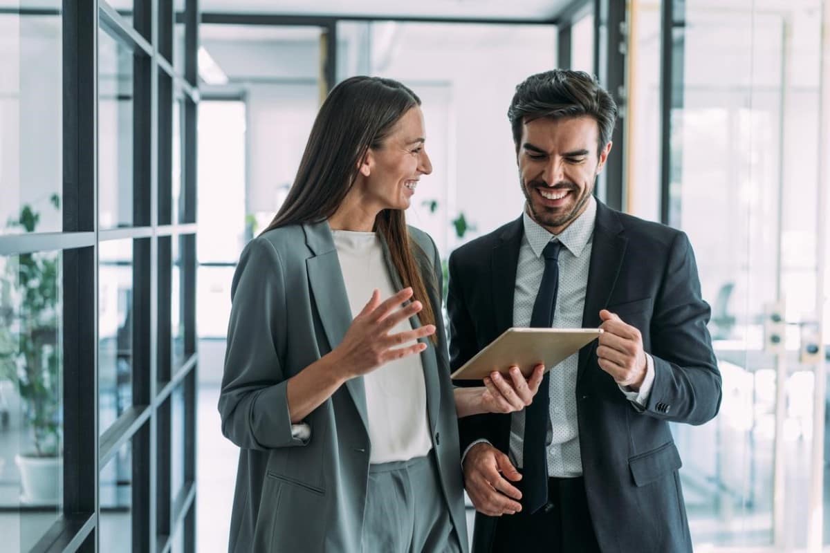 Personas de negocios conversan de swaps y analizan información en una tablet.