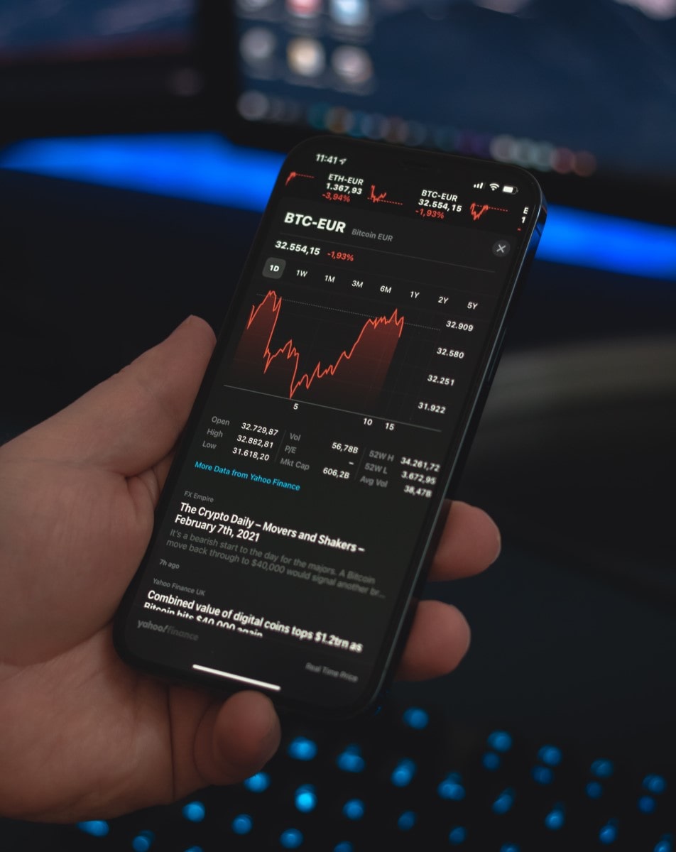 Persona viendo en su celular gráficos sobre el comportamiento de las criptomonedas.