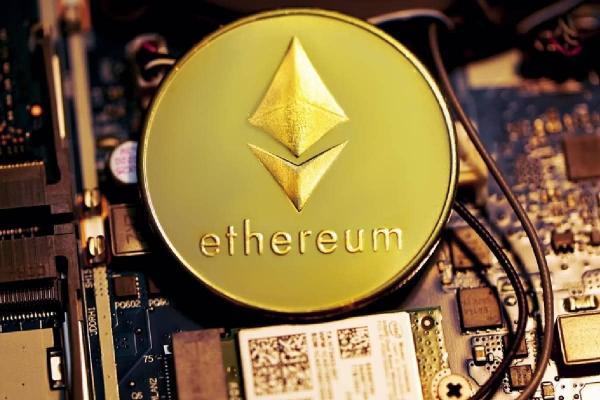 Moneda grabada con la palabra “Ethereum” y el logotipo, sobre una placa de computadora. 