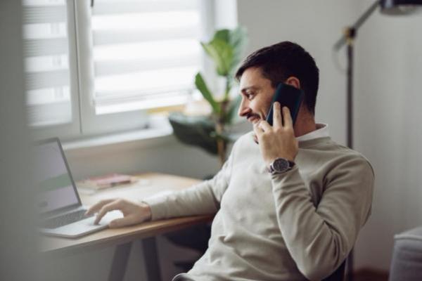 Joven conversa por celular sobre la posibilidad de invertir en un fondo de inversión indexado.