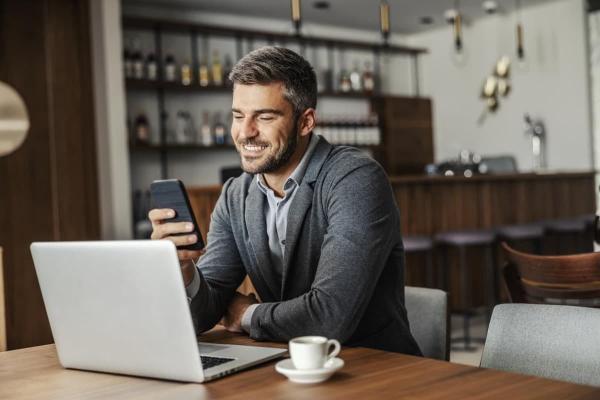Un hombre de negocios analiza en su celular los resultados de una inversión pasiva.