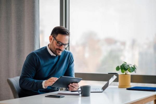 Empresario investiga en su tablet tendencias para invertir en materias primas.