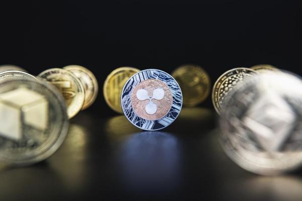 Un ripple y otras crypto sobre una superficie oscura. Con cualquiera de ellas se puede practicar el minado de criptomonedas.