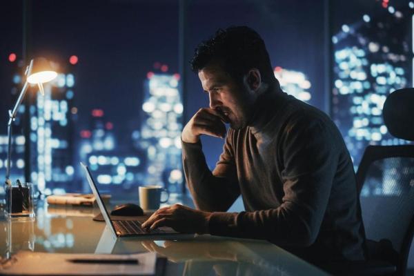 Un hombre de negocios investiga en su laptop sobre el mercado OTC.