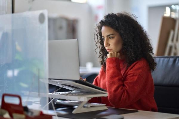 Una joven consulta en su computadora la pregunta de “cómo invertir mi dinero".