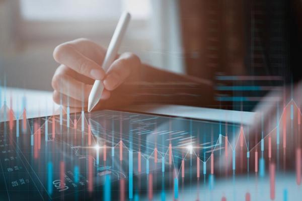 Un trader revisa gráficos de indicadores económicos en su tablet.