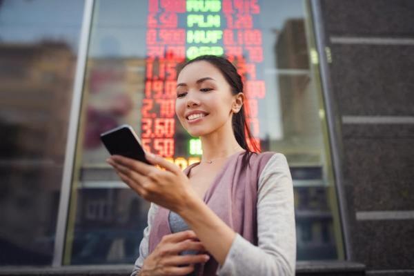  Una joven revisa en su celular la tasa de cambio del euro dólar. 