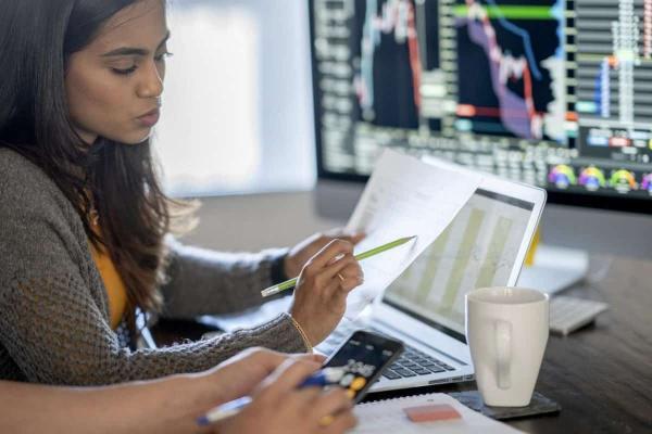 Dos jóvenes inversionistas analizan datos sobre las acciones baratas.