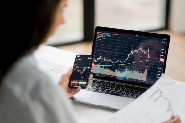 Una inversionista analiza datos de la bolsa de valores desde sus dispositivos móviles.