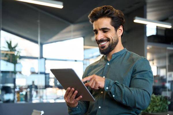 Empresario investiga en su tablet cuáles son los mejores instrumentos de inversión.
