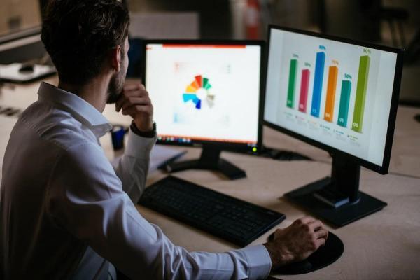 Un empresario realiza en sus computadoras un análisis de oportunidades de mercado.