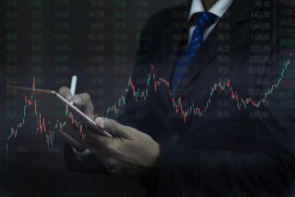 Un hombre revisa gráficas y números en su tablet para comprar acciones en Ecuador.