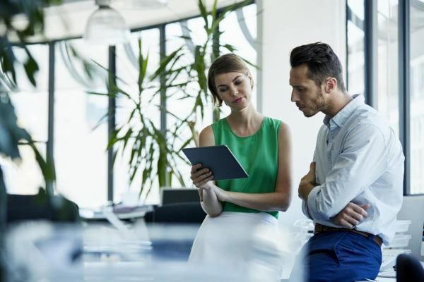 Una pareja de empresarios analiza en su tablet las mejores inversiones en Colombia.