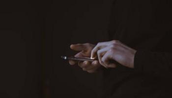 Una persona con un celular en las manos mientras ingresa a su billetera virtual.